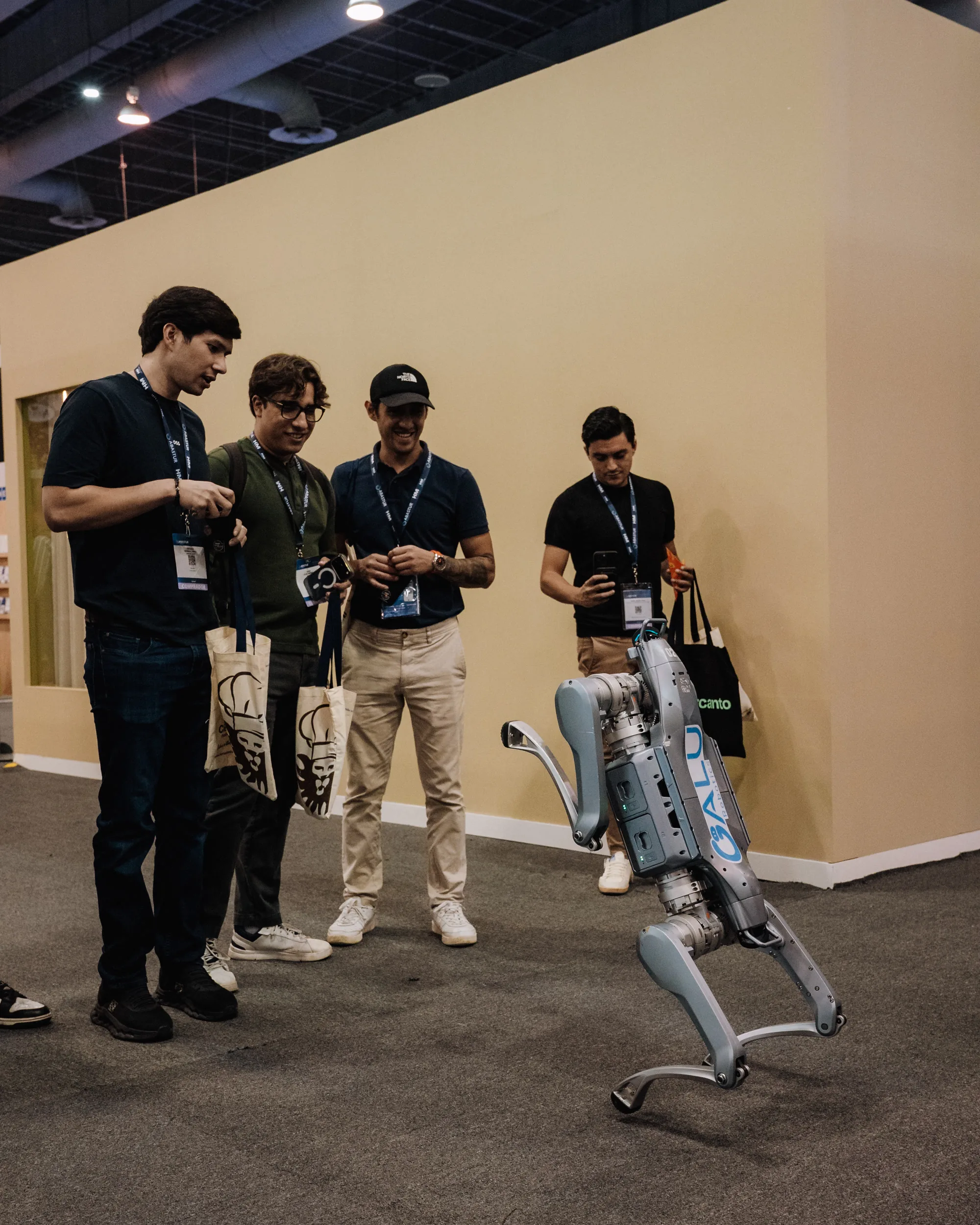 Visitantes de una exposición observan un robot cuadrúpedo de Galu Robotics