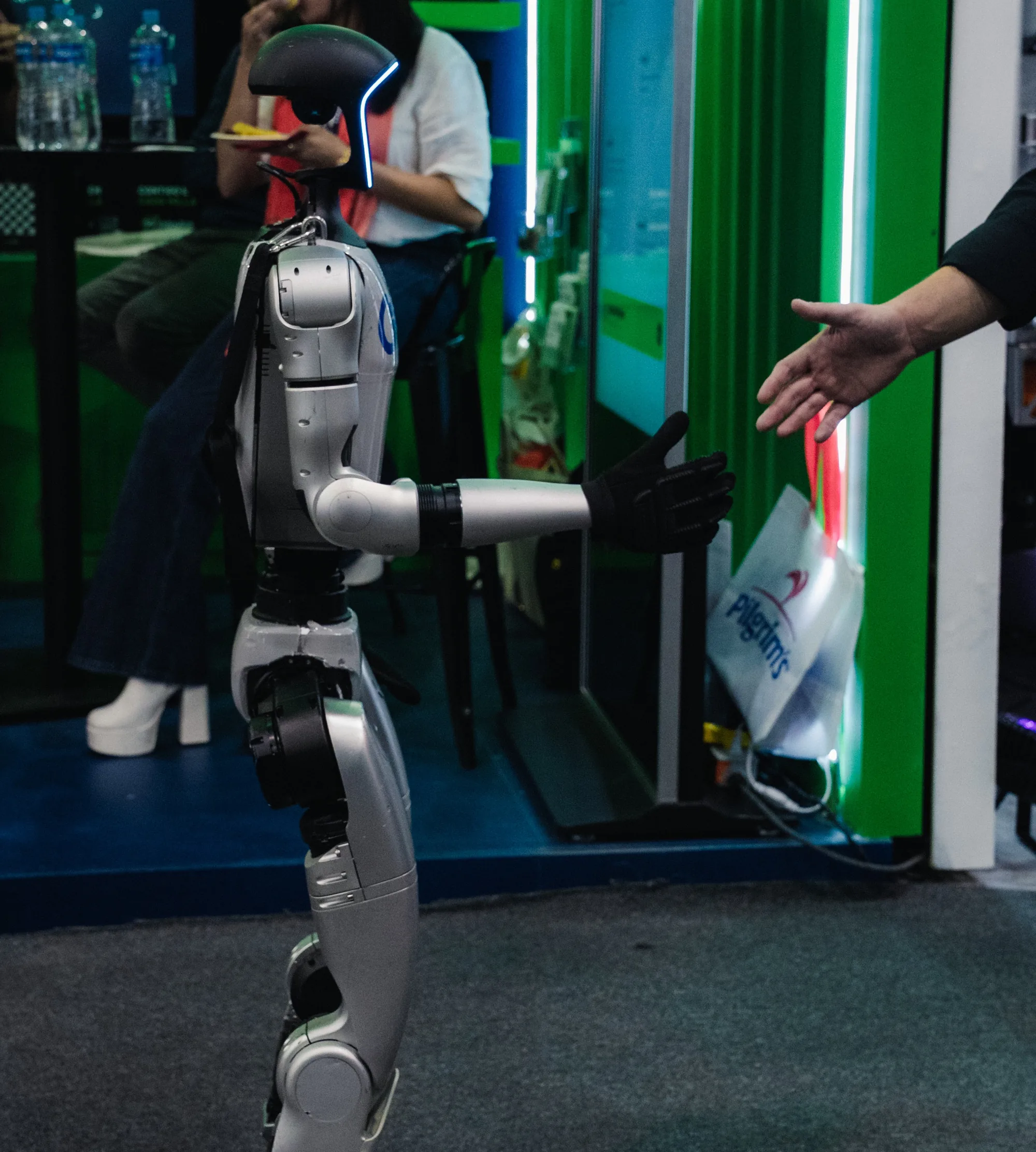Humanoide Unitree G1 de Galu Robotics extendiendo la mano a un visitante en expo