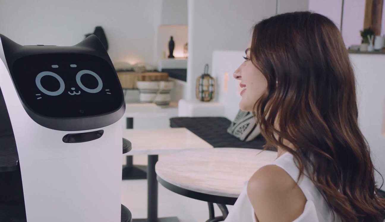 La pantalla facial de BellaBot frente a una clienta.